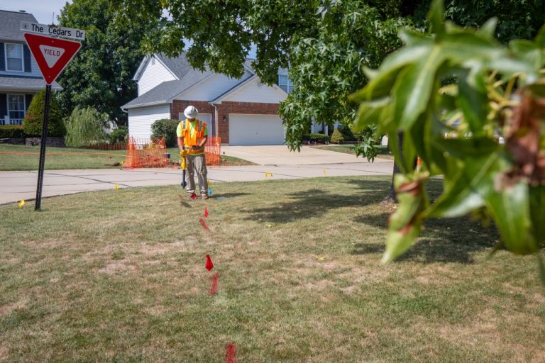 Alt: Aerial view of a buildable land parcel showing utility access points and topography.